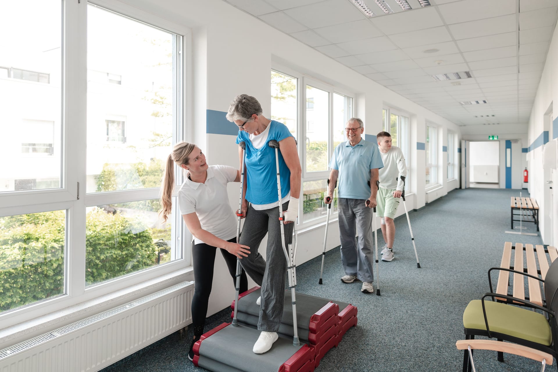 Physiotherapeutin hilft Patientin beim Gehtraining in der Reha.