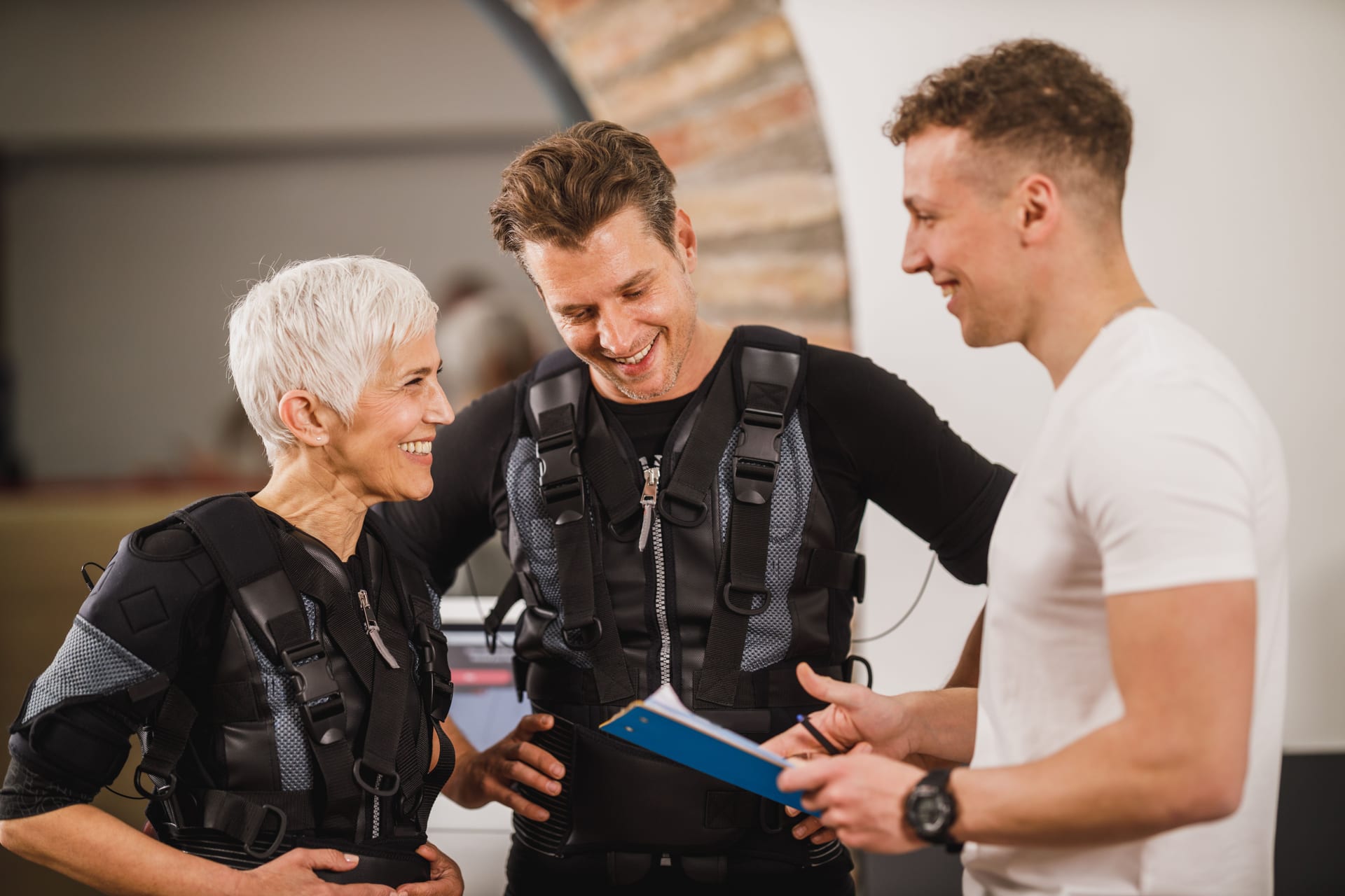 Fitnesstrainer bespricht Trainingsplan mit Kunden im Studio.